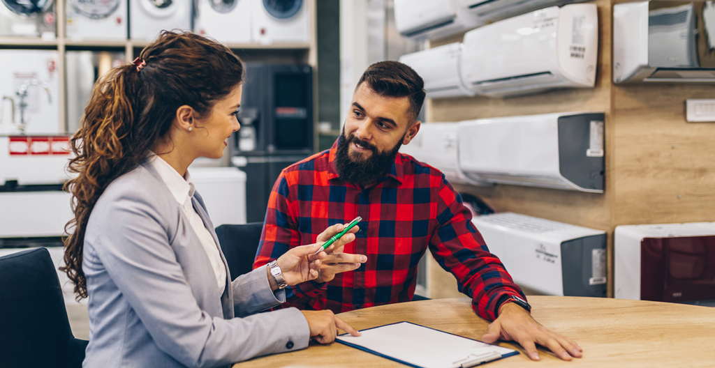 Client en discussion avec conseiller électroménager dans un magasin indépendant de proximité